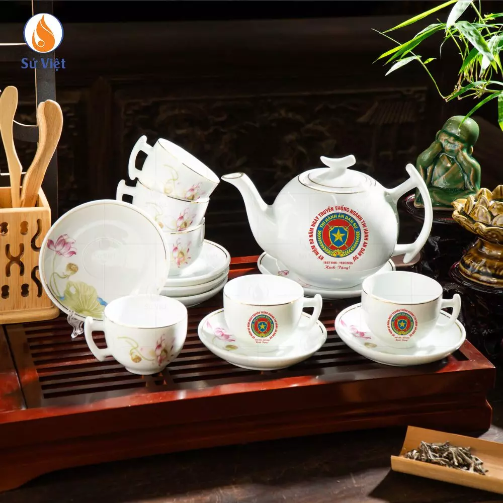 Bộ Ấm Chén Liên Hoa In Logo Kỉ Niệm 80 Năm Ngành THADS Bộ Ấm Chén Liên Hoa In Logo Kỷ Niệm 80 Năm Ngành THADS không chỉ là một vật phẩm quà tặng mang dấu ấn nhận diện riêng của ngành, mà còn là món quà chứa đựng sự trân trọng dành cho hành trình tám thập kỷ bền bỉ phụng sự công lý, giữ gìn kỷ cương pháp luật và bảo vệ những giá trị công bằng trong đời sống xã hội. Giữa rất nhiều lựa chọn quà tặng kỷ niệm, một bộ ấm chén mang vẻ đẹp truyền thống của gốm sứ Việt luôn gợi nên cảm giác gần gũi, trang trọng và có chiều sâu văn hóa đặc biệt. Vẻ đẹp của hoa sen trong nghệ thuật gốm sứ Lấy cảm hứng từ hình tượng hoa sen thanh tao, Bộ Ấm Chén Liên Hoa mang trong mình nét đẹp nhẹ nhàng nhưng đầy khí chất. Trong văn hóa Việt Nam, hoa sen không chỉ tượng trưng cho sự thanh sạch, bền bỉ và cao quý, mà còn gợi nhắc đến tinh thần kiên định, vững vàng trước mọi thử thách. Khi được đưa vào thiết kế gốm sứ, từng đường nét cánh sen hiện lên mềm mại, hài hòa và tạo nên tổng thể trang nhã cho bộ sản phẩm. Sự kết hợp giữa họa tiết Liên Hoa cùng logo kỷ niệm 80 năm ngành Thi hành án dân sự không chỉ giúp món quà mang giá trị nhận diện riêng, mà còn tạo nên dấu ấn lưu niệm ý nghĩa dành cho cán bộ, đối tác và các đơn vị đồng hành trong dịp đặc biệt này. Gìn giữ dấu son 80 năm bằng nghệ thuật gốm Việt Một món quà kỷ niệm ý nghĩa không nằm ở sự cầu kỳ, mà nằm ở cảm xúc và giá trị mà nó lưu giữ theo thời gian. Logo 80 năm được in trang trọng trên bộ ấm chén như một lời nhắc nhớ về chặng đường phát triển đáng tự hào của ngành Thi hành án dân sự – hành trình của sự tận tâm, trách nhiệm và cống hiến không ngừng nghỉ. Mỗi lần rót trà, mỗi cuộc gặp gỡ bên chén trà ấm cũng trở thành một khoảnh khắc gợi nhớ về truyền thống ngành, về những con người đã và đang góp phần xây dựng nền tư pháp ngày càng vững mạnh. Đó không chỉ là món quà sử dụng trong đời sống thường ngày, mà còn là vật phẩm mang giá trị tinh thần và ý nghĩa lưu niệm lâu dài. Chất gốm Bát Tràng – Giá trị của sự bền vững Được chế tác từ chất gốm Bát Tràng truyền thống, bộ ấm chén mang vẻ đẹp mộc mạc nhưng tinh tế, với nước men sáng đẹp, bề mặt mịn và độ bền cao. Từng công đoạn từ tạo hình, nung đốt đến hoàn thiện họa tiết đều được thực hiện tỉ mỉ, giúp sản phẩm vừa đảm bảo công năng sử dụng, vừa mang tính thẩm mỹ và nghệ thuật. Trong không gian tiếp khách, phòng họp hay trên bàn trà gia đình, Bộ Ấm Chén Liên Hoa luôn tạo cảm giác trang trọng, gần gũi và đậm nét văn hóa Việt. Đây cũng là dòng quà tặng phù hợp với nhiều đối tượng, từ cán bộ trong ngành đến khách mời, đối tác và các đơn vị phối hợp. Món quà kết nối truyền thống và hiện tại Kỷ niệm 80 năm ngày truyền thống ngành Thi hành án dân sự không đơn thuần là một dấu mốc thời gian, mà còn là dịp để nhìn lại hành trình phát triển, tri ân những thế hệ đi trước và tiếp nối những giá trị tốt đẹp cho chặng đường phía trước. Một bộ ấm chén tưởng chừng giản dị lại có thể trở thành cầu nối của sự gắn kết, sự trân trọng và niềm tự hào nghề nghiệp. Bộ Ấm Chén Liên Hoa In Logo Kỷ Niệm 80 Năm không chỉ là món quà mang tính lưu niệm, mà còn là lời tri ân dành cho những đóng góp thầm lặng của nhiều thế hệ cán bộ trong hành trình giữ gìn sự công bằng và kỷ cương pháp luật. Với vẻ đẹp trang nhã của gốm sứ truyền thống cùng ý nghĩa sâu sắc được gửi gắm trong từng chi tiết, món quà ấy sẽ tiếp tục thay lời chúc cho sự gắn kết, bền vững và niềm tự hào của một chặng đường đáng nhớ.